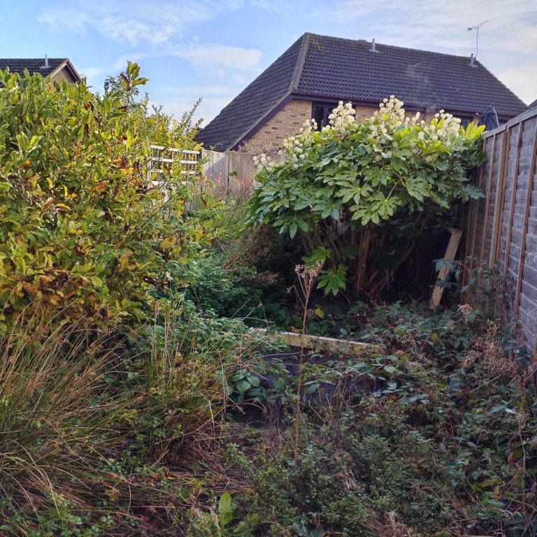 A man using a pole to clean a window from outside a two-storey house.