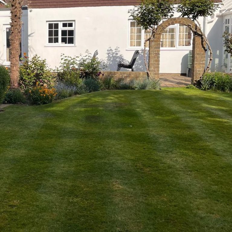 A person using a pressure washer to clean a patio surface.