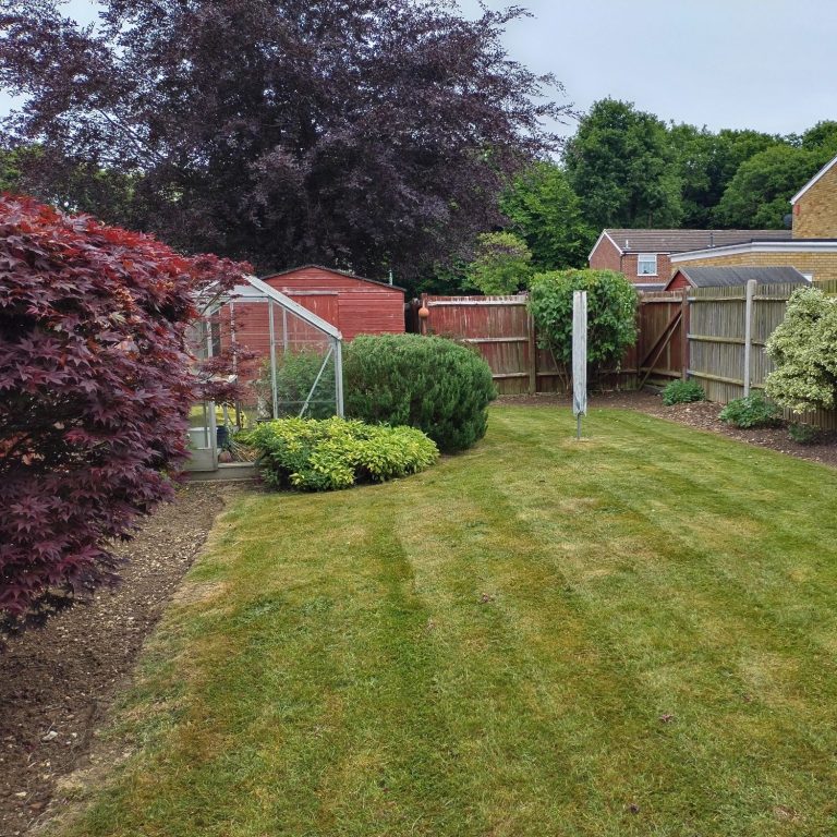A person using a pressure washer to clean a patio surface.